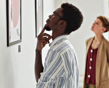 Man and woman looking at art on wall